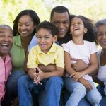 Extended family sitting outdoors smiling