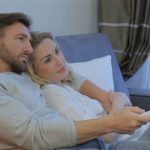 attractive-caucasian-couple-watching-tv-at-home-lovely-couple-lying-embracing-on-the-couch-pretty-blond-woman-lying-on-the-mans-shoulder_ru_pklxxl_thumbnail-full01_Fotor