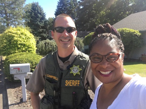 Oregon state Rep. Janelle Bynum takes a photo with a Clackamas County deputy who responded to a 911 call from one of her constituents who thought she looked suspicious as she was canvassing in a Clackamas neighborhood on July 3, 2018. (Courtesy of Janelle Bynum)