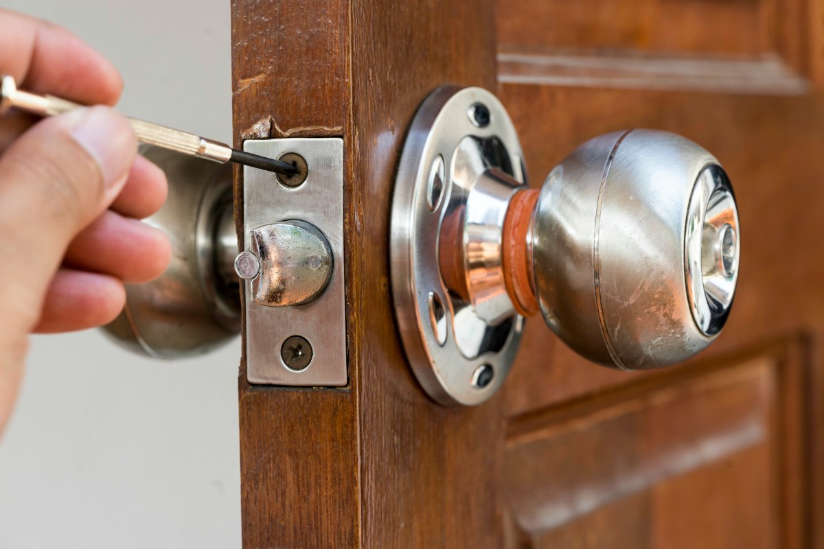 closeup of locksmith on old wood door , repair