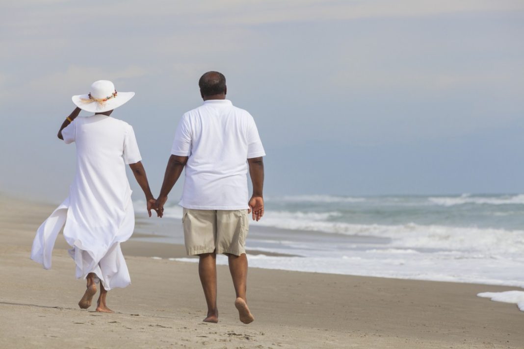 black couple vacation beach, financial freedom