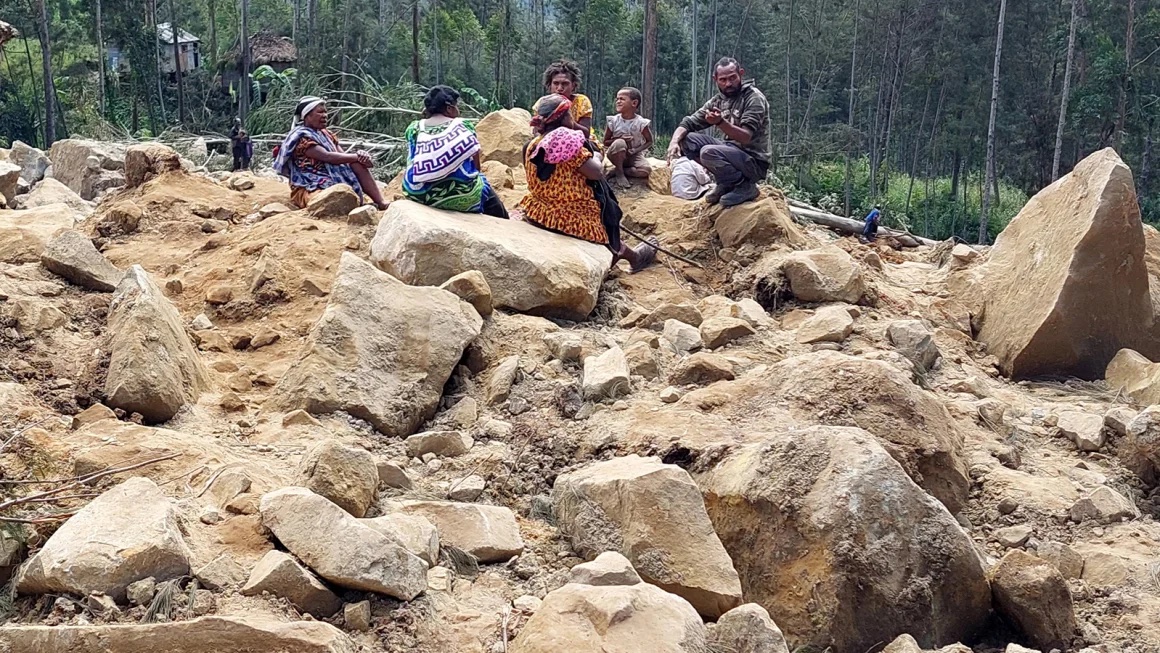 People gather at the site of a landslide in Papua New Guinea's Enga Province. | Stringer/AFP/Getty Images