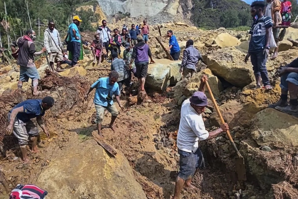 People gather at the site of a landslide in Papua New Guinea's Enga Province. Stringer/AFP/Getty Images