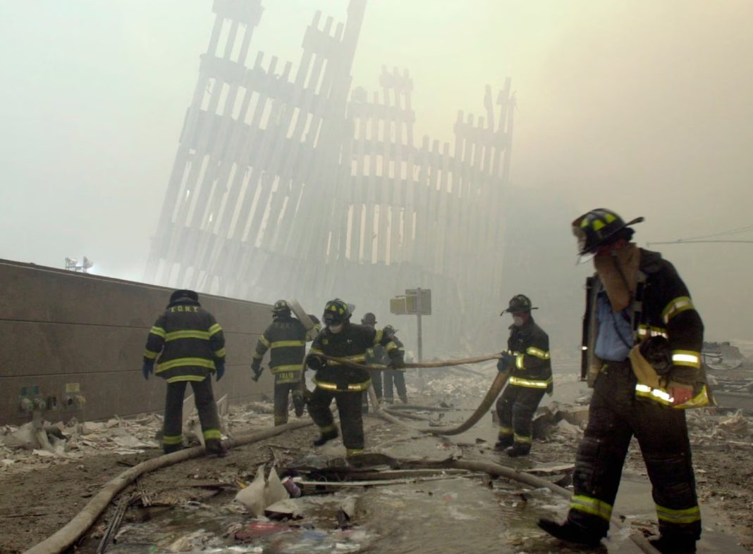 September 11, New York City firefighters work amid debris in this Sept. 11, 2001, photo, with the skeleton of the World Trade Center