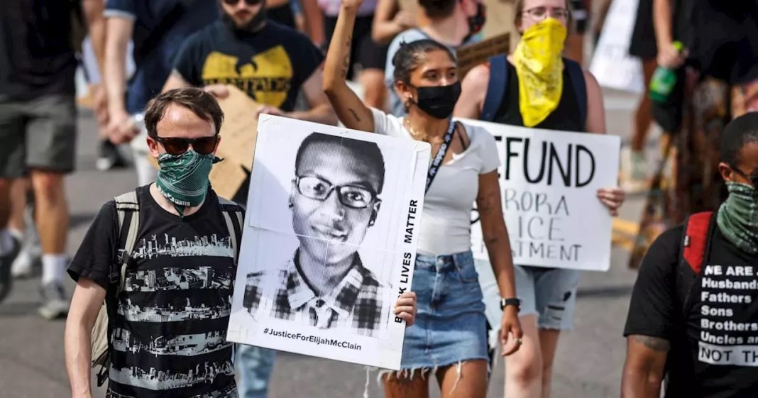 paramedic, Demonstrators carry placards as they walk down Sable Boulevard during a rally and march over the death of Elijah McClain in Aurora, Colorado on June 27, 2020 | David Zalubowski/AP