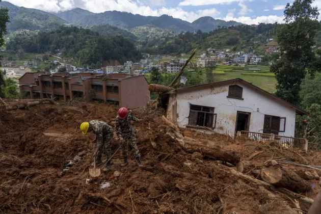 Rescuers search for the body of a missing doctor after a landslide damaged a house in the Anandaban hospital, in Lalitpur, Nepal, Tuesday, Oct. 1, 2024. (AP Photo/Niranjan Shrestha)