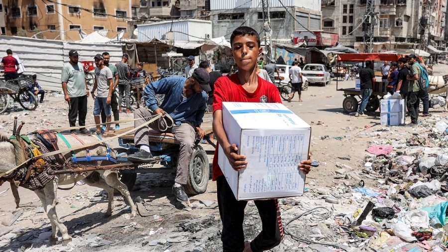 Palestinian Refugees, A boy carries a humanitarian aid package provided by the United Nations Relief and Works Agency for Palestine Refugees (UNRWA) in central Gaza City on August 27. Omar Al-Qattaa/AFP/Getty Images