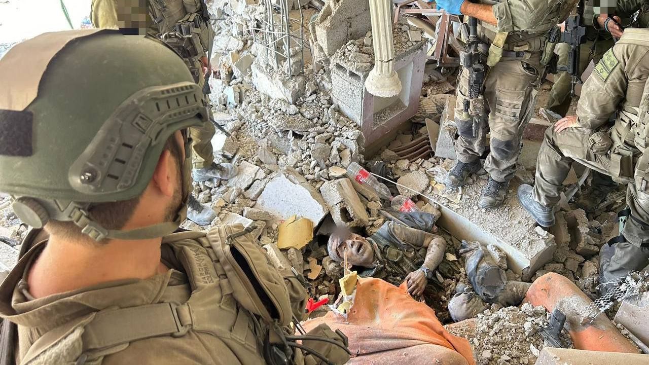 This image appears to show the body of Hamas leader Yahya Sinwar lying in the rubble of a destroyed building, with Israeli soldiers standing around the body. Obtained by CNN