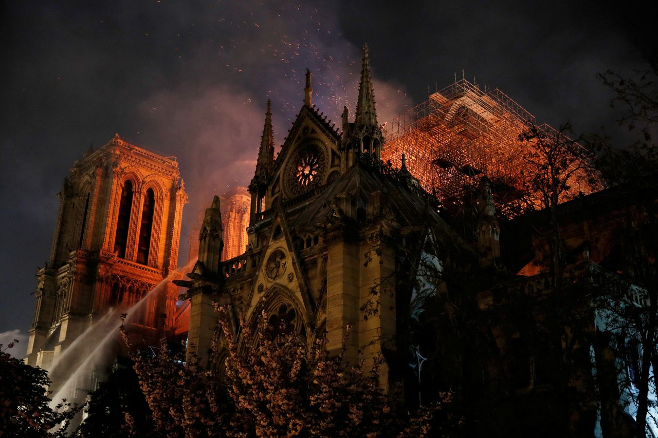 Sparks fill the air as Paris firefighters battle to extinguish flames. | Philippe Wojazer/Reuters