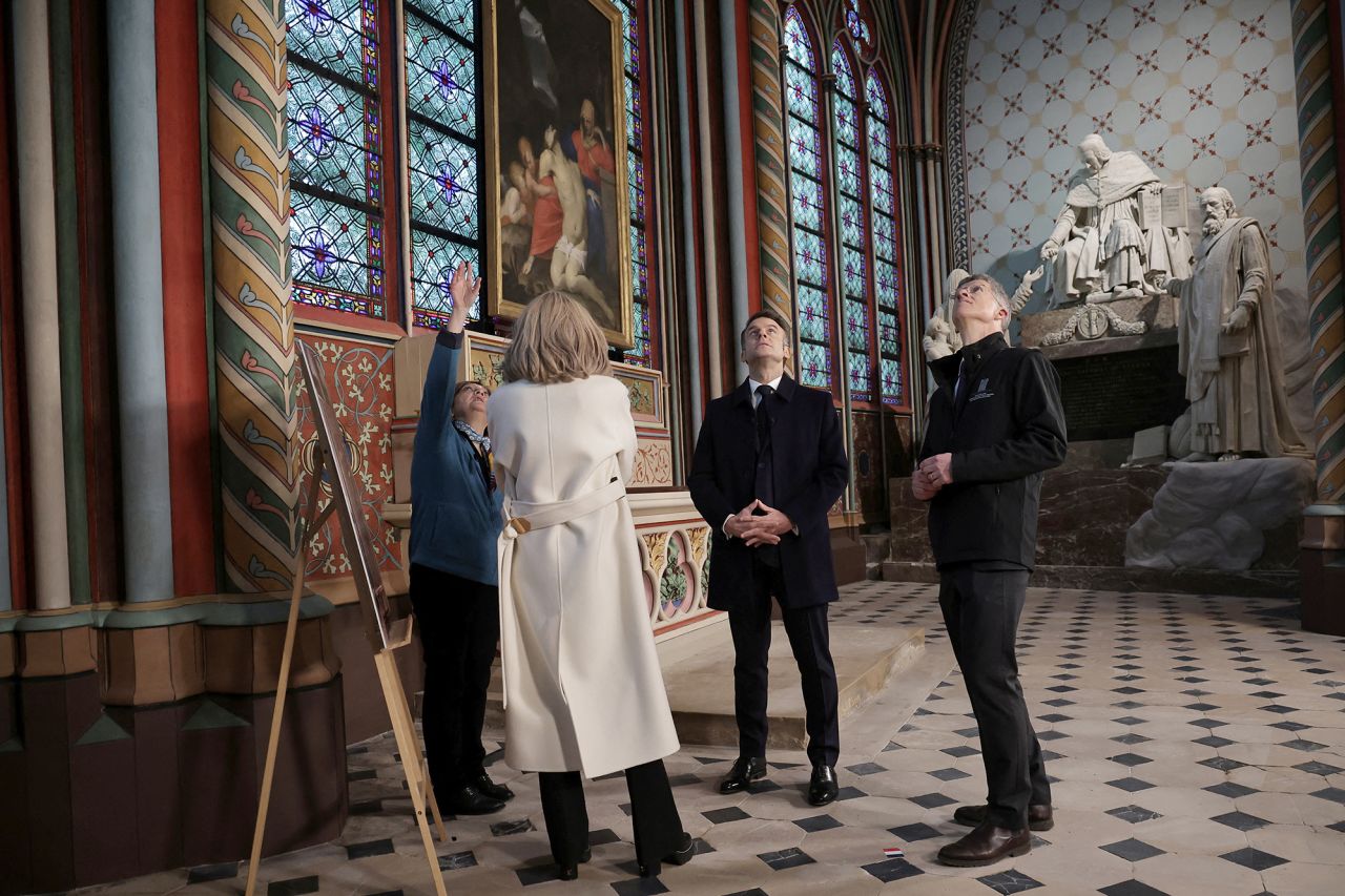 President Emmanuel Macron meets with Marie Parant, who restored wall paintings in the St Marcel's chapel at the Notre Dame cathedral. | Christophe Petit Tesson/Reuters 