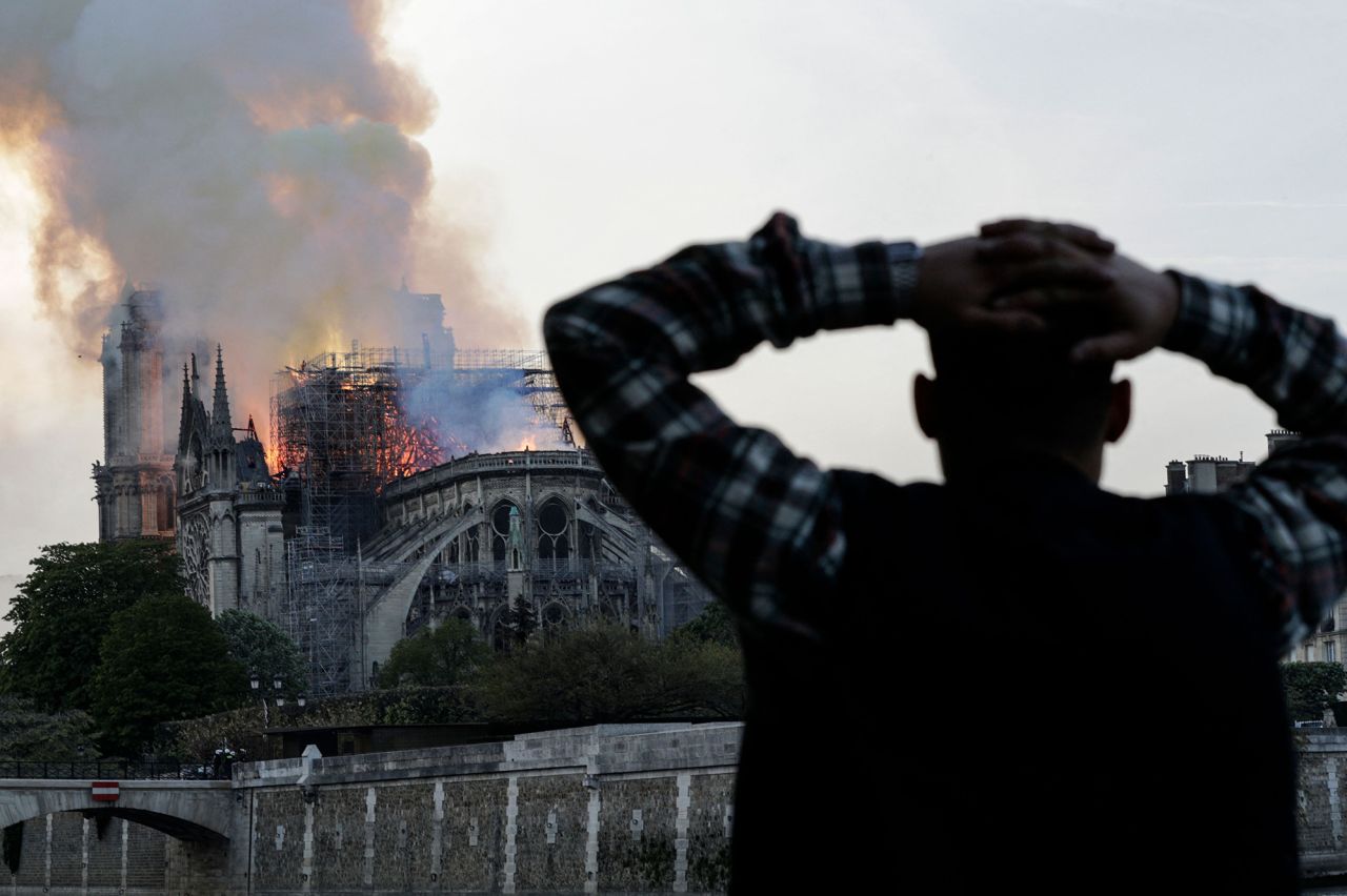 A man watches the cathedral engulfed in flames, as the fire swept through the roof. | Geoffroy Van Der Hasselt/AFP/Getty Images