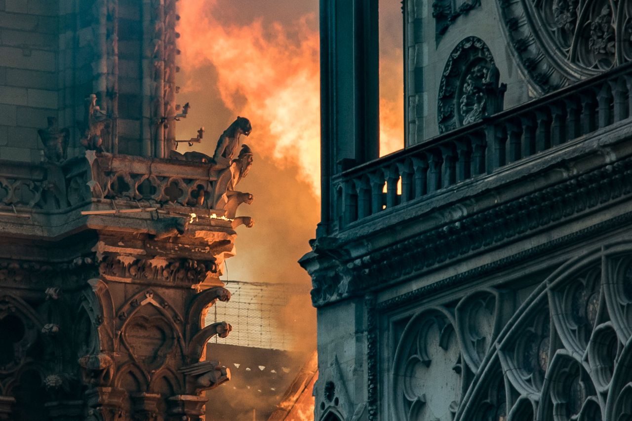 Flames and smoke billow around the gargoyles decorating the roof and sides of Notre Dame. | Thomas Samson/AFP/Getty Images