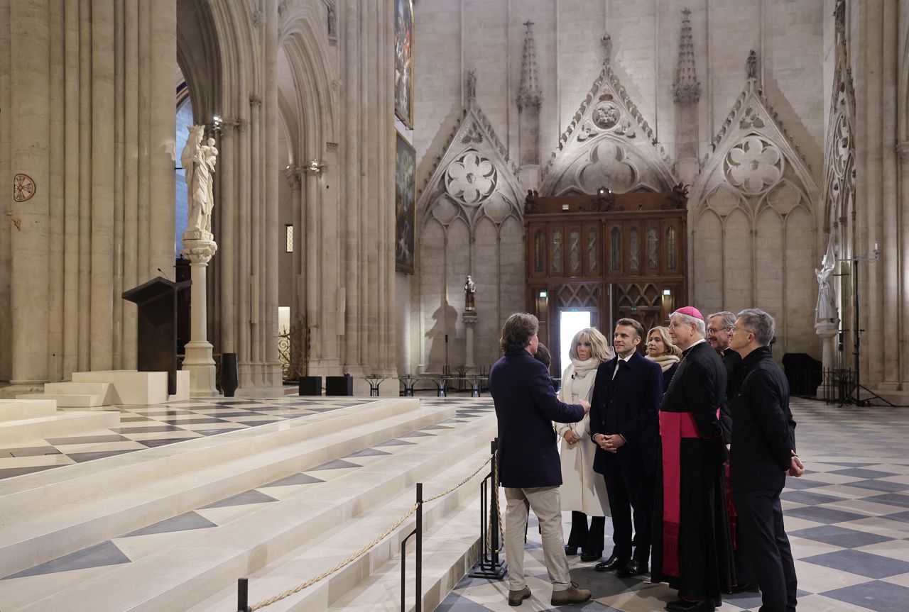 French President Emmanuel Macron, his wife Brigitte Macron and Paris' archbishop Laurent Ulrich visit Notre Dame cathedral and stop in front of the Virgin of Paris statue. | Christophe Petit Tesson/AFP/Getty Images 