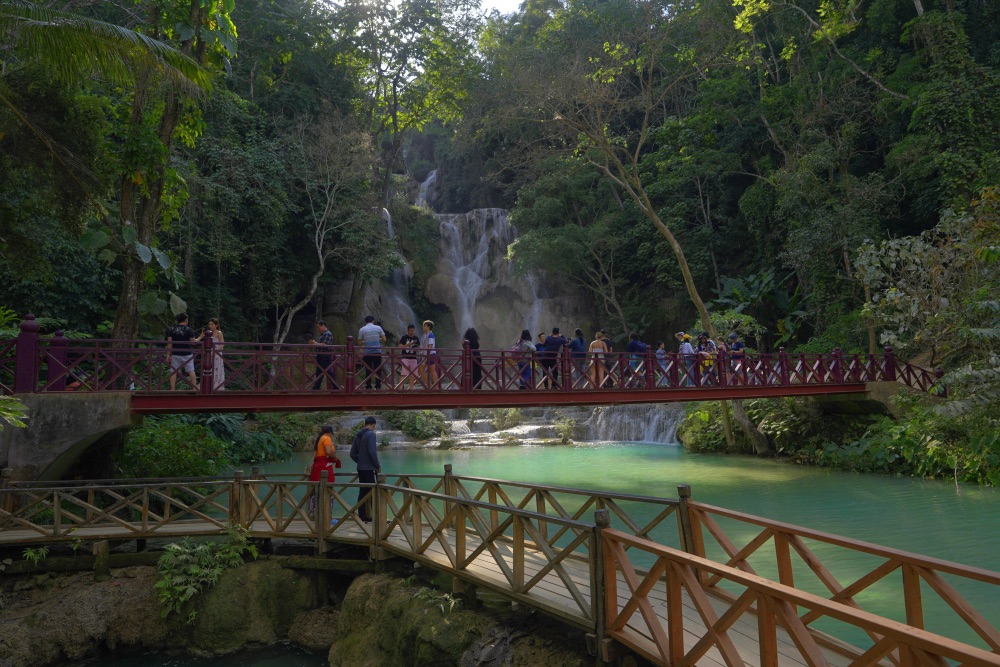 Tourists on a bridge at Nong Khiaw, Laos | Teodor Kuduschiev/Unsplash