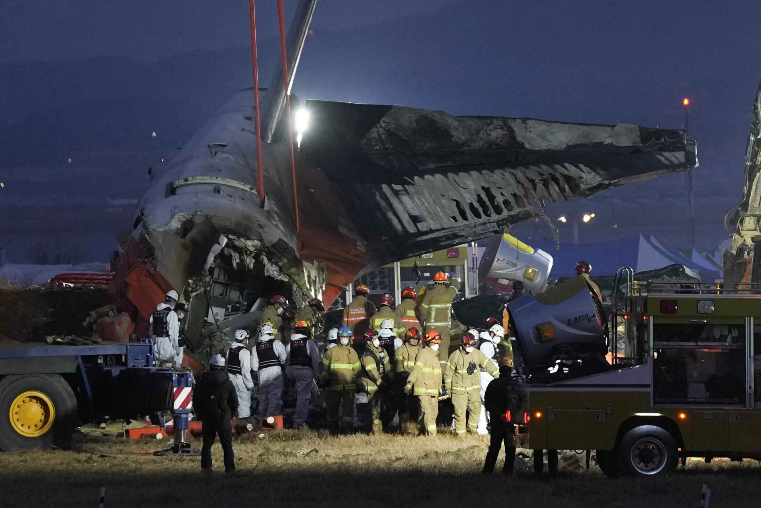  Rescue team members carry the body of a passenger at the site of a plane fire where a Jeju Air plane crashed at Muan International Airport in Muan, South Korea, Sunday, December 29, 2024. | AP Photo/Ahn Young-soon 