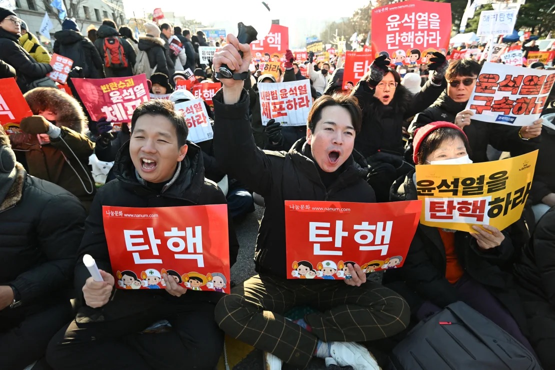 People shout slogans calling for Yoon's impeachment outside the National Assembly in Seoul on December 14, 2024. | Jung Yeon-Je/AFP/Getty Images