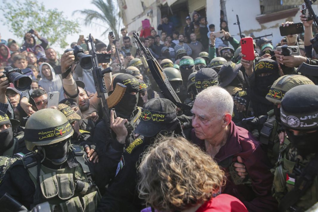 Israeli Hostages, Gadi Mozes, center right, is escorted by Hamas and Islamic Jihad fighters as he is handed over to the Red Cross in Khan Younis, Gaza, on Thursday, January 30, 2025. | Jehad Alshrafi/AP