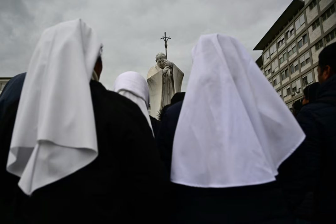 Pope Francis, Nuns pray at the statue of John Paul II outside Gemelli University Hospital, where Pope Francis is hospitalized with pneumonia. | Tiziana Fabi / AFP - Getty Images