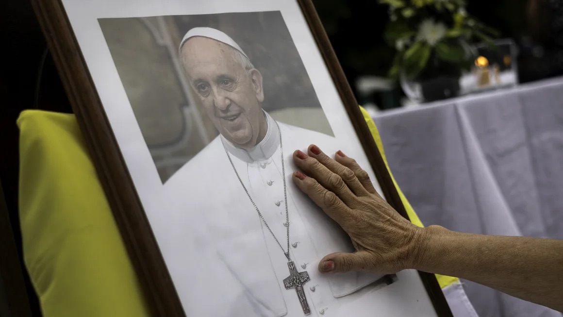 A woman touches a portrait of Pope Francis on February 24, 2025, in Buenos Aires, Argentina. | John Moore/Getty Images